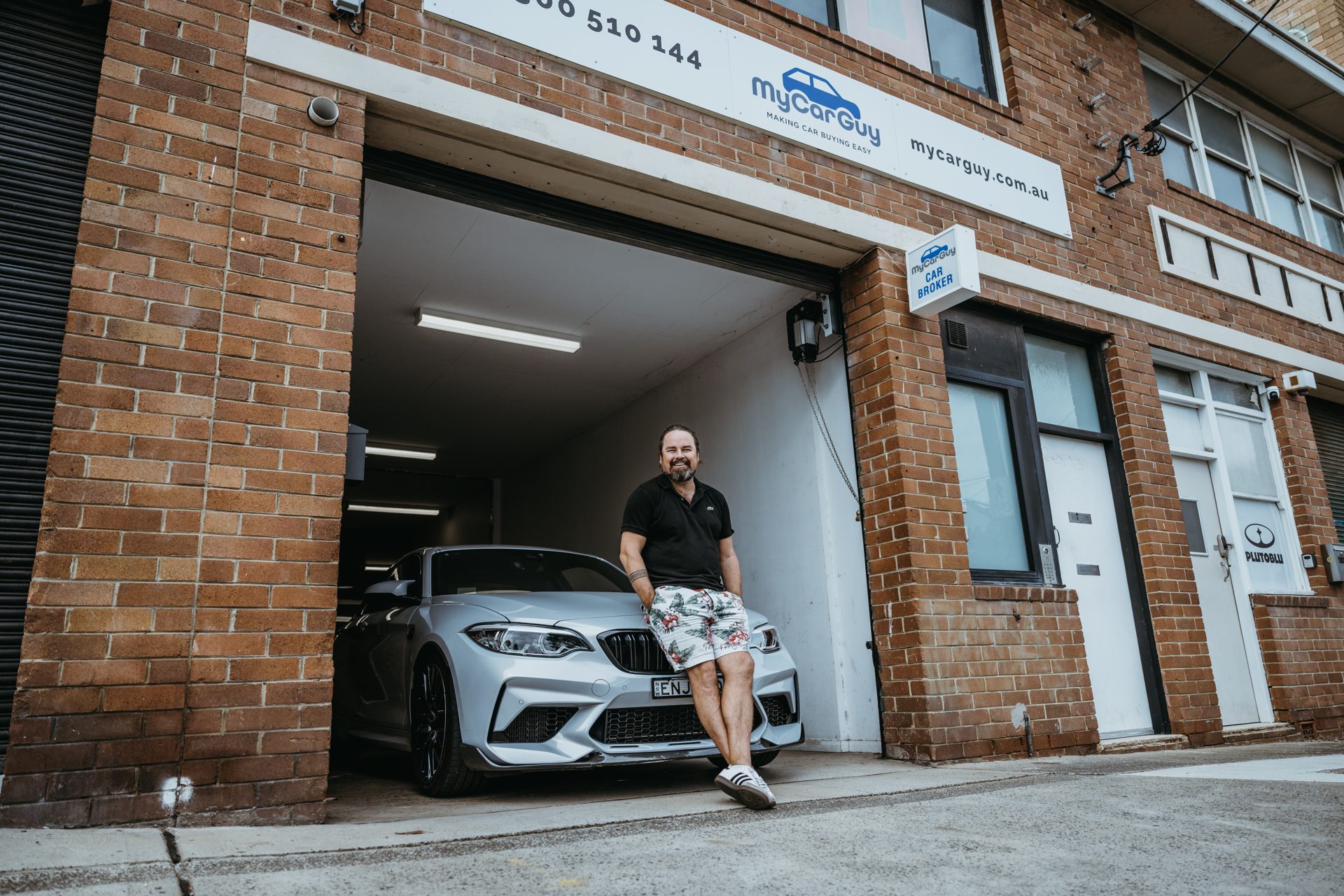 Dave Lenehan at the My Car Guy storefront with a BMW M2
